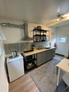 a kitchen with a sink and a stove at Small cozy apartment in Tromsø
