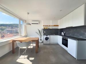 a kitchen with white cabinets and a wooden table at Studio Rosa in Gabrovo