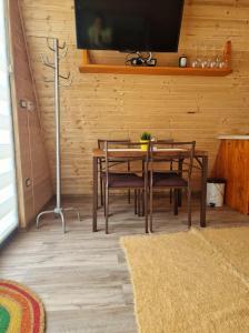 a dining room with a table and chairs and a tv at Bucovina-A-FrameHouse-HotTub-Fireplace-Patio-WiFi in Suceviţa