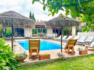 a swimming pool with chairs and umbrellas in a yard at Countryside Villa near Porto in Paredes