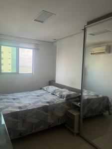 a bedroom with a bed and a mirror at Ótimo apartamento na linda praia de Manaíra in Tambaú +4 photos