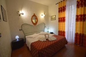 ローマにあるホテル アレクシスのベッドルーム1室(ベッド1台、鏡、カーテン付)
