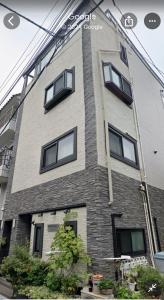 a building with windows on the side of it at Dain Hostel1 in Tokyo