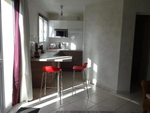 a kitchen with two red chairs and a table at Maisonnette proche de Chartres avec Wifi in Saint-Prest