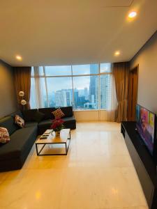 a living room with a couch and a large window at APARTMENT VorteX KLCC in Kuala Lumpur