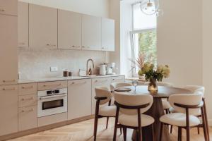 a kitchen with white cabinets and a table and chairs at Soho Apartment - Wrocław Old Town in Śródmieście