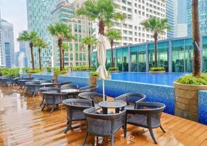 a hotel patio with tables and chairs and a pool at APARTMENT VorteX KLCC in Kuala Lumpur