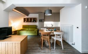 a kitchen and living room with a table and chairs at Residence Contrin in Canazei
