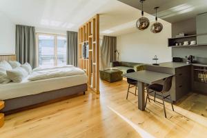 a bedroom with a bed and a desk and a kitchen at KABINETT Boutique Apartments in Kröv