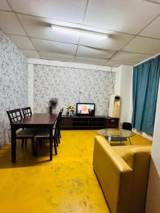 a living room with a table and a couch at Bilik Bajet BDS in Temerloh