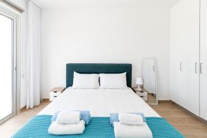 ein weißes Schlafzimmer mit einem großen Bett mit zwei Kissen in der Unterkunft Villa Wave Blue by Ezoria Villas in Klorakas