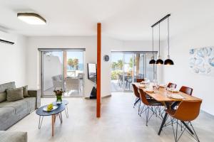 ein Wohnzimmer mit Tisch und Couch in der Unterkunft Villa Wave Blue by Ezoria Villas in Klorakas