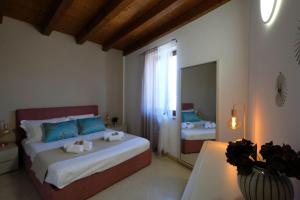 a bedroom with two beds and a table and a mirror at Corvina By Zeni in Costermano sul Garda