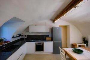 a kitchen with white cabinets and a stainless steel refrigerator at Corvina By Zeni in Costermano sul Garda