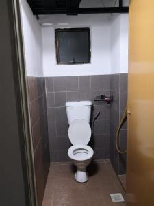Un baño con un inodoro blanco en una cabina. en Bilik Bajet BDS 2, en Temerloh