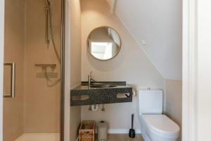 デ・ハーンにあるHuswell - Beautiful home for 14 guests , pets are welcomeの洗面台、トイレ、鏡のあるバスルーム