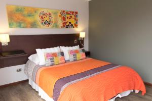 1 dormitorio con 1 cama con manta naranja en Small Hotel Goblin´s House, en Temuco