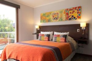 1 dormitorio con 1 cama con manta naranja en Small Hotel Goblin´s House, en Temuco