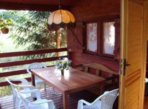 a wooden table and chairs on the porch of a cabin at Domki drewniane alpejskie in Świętne