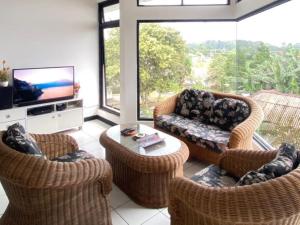 a living room with wicker chairs and a television at Villa Gunung Bhakti in Pasakon 1