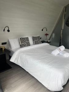 a bedroom with a large white bed with pillows at Xanelas Do Monte in Mos