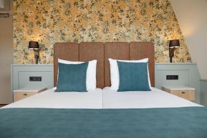 东弗利兰Boutiquehotel het Eiland的卧室里有一张大床，配有蓝色枕头