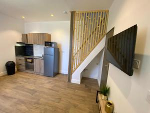 a kitchen with a refrigerator and a staircase in a room at Maison de ville in Fenouillet
