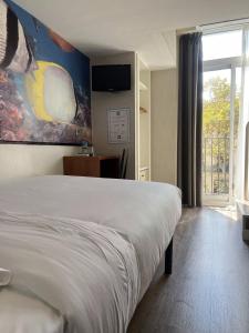a bedroom with a bed with a painting on the wall at Standbyme Ramblas in Barcelona