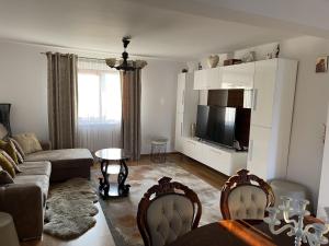 a living room with a couch and a tv at Bucovina-MountainHouse-5Br-Fireplace-HotTub-WiFi in Suceviţa