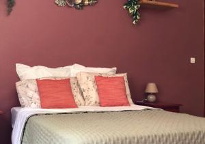 Un dormitorio con una cama con dos almohadas rojas. en La Suite Sapotille, en Trois-Rivières