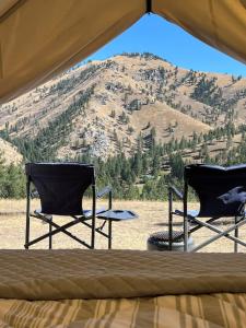 two chairs in a tent with a view of a mountain at Tent 2 Oxen-Le-Fields Montana in Conner
