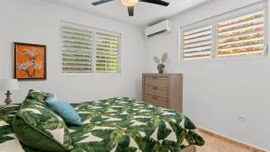 リンコンにあるCasita 4 at Ceiba Tree Inn. Tranquility with Garden Views and Pergola with Ocean Overlookのベッドと天井扇風機のある寝室