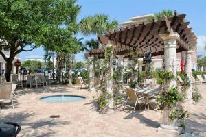 a patio with a table and chairs and a pavilion at Seacrest - The Wellington in Panama City Beach