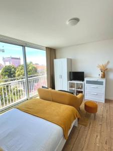 a bedroom with a bed and a large window at Domus da Ria - Alboi III in Aveiro