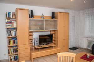 a living room with wooden book shelves and a tv at Ferienwohnung Bäumer Borkum - Nichtraucher & allergikerfreundlich in Borkum