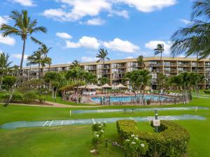 a resort with a swimming pool and palm trees at Maui Sunset A413 in Kihei