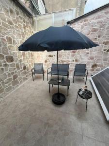 un gruppo di sedie e un ombrellone su un patio di Maison Centre ville 3 chambres a Calais