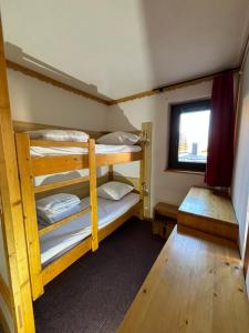 a room with two bunk beds and a window at Appartement Eskival skis aux pieds in Val Thorens