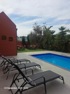 a group of lounge chairs next to a swimming pool at Saint's Inn in Parklands