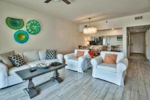 a living room with two white couches and a table at Seacrest - Beach Blessing in Panama City Beach