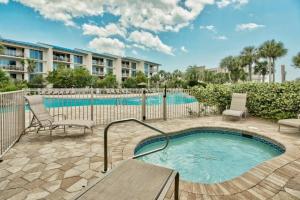a swimming pool with chairs and a bench next to a building at Seacrest - Beach Blessing in Panama City Beach