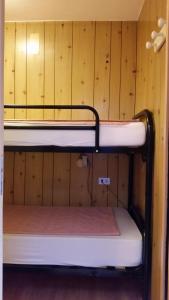 マリッレーヴァにあるResidence Lores 2の二段ベッドが備わる木製の壁の客室です。