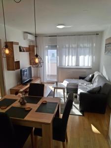 una sala de estar con un sofá y una mesa en Apartman Nina, en Špansko