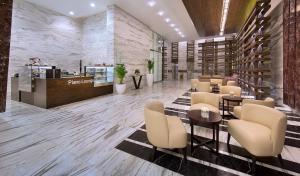 a lobby of a restaurant with tables and chairs at Atana Hotel in Dubai