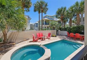 basen z czerwonymi krzesłami oraz stołem i krzesłami w obiekcie Seacrest - 113 Geoff Wilder w mieście Rosemary Beach