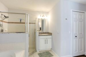 a white bathroom with a shower and a sink at Inviting Jensen Beach Home with Screened-In Patio! in Jensen Beach +29 photos