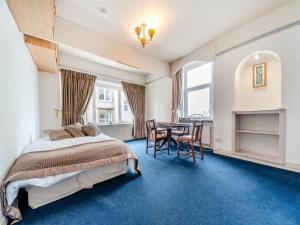 una camera da letto con un letto, un tavolo e delle sedie di Bay View a Oban