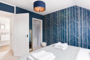 a bedroom with a bed with a blue wall at Charlotte Street Apartment in Bath