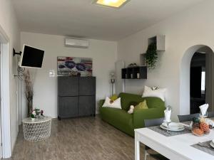 Una sala de estar con un sofá verde y una mesa. en Villa Renè, en Tenno