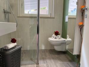 Un baño con inodoro y ducha de cristal. en Villa Renè, en Tenno 19 fotos más